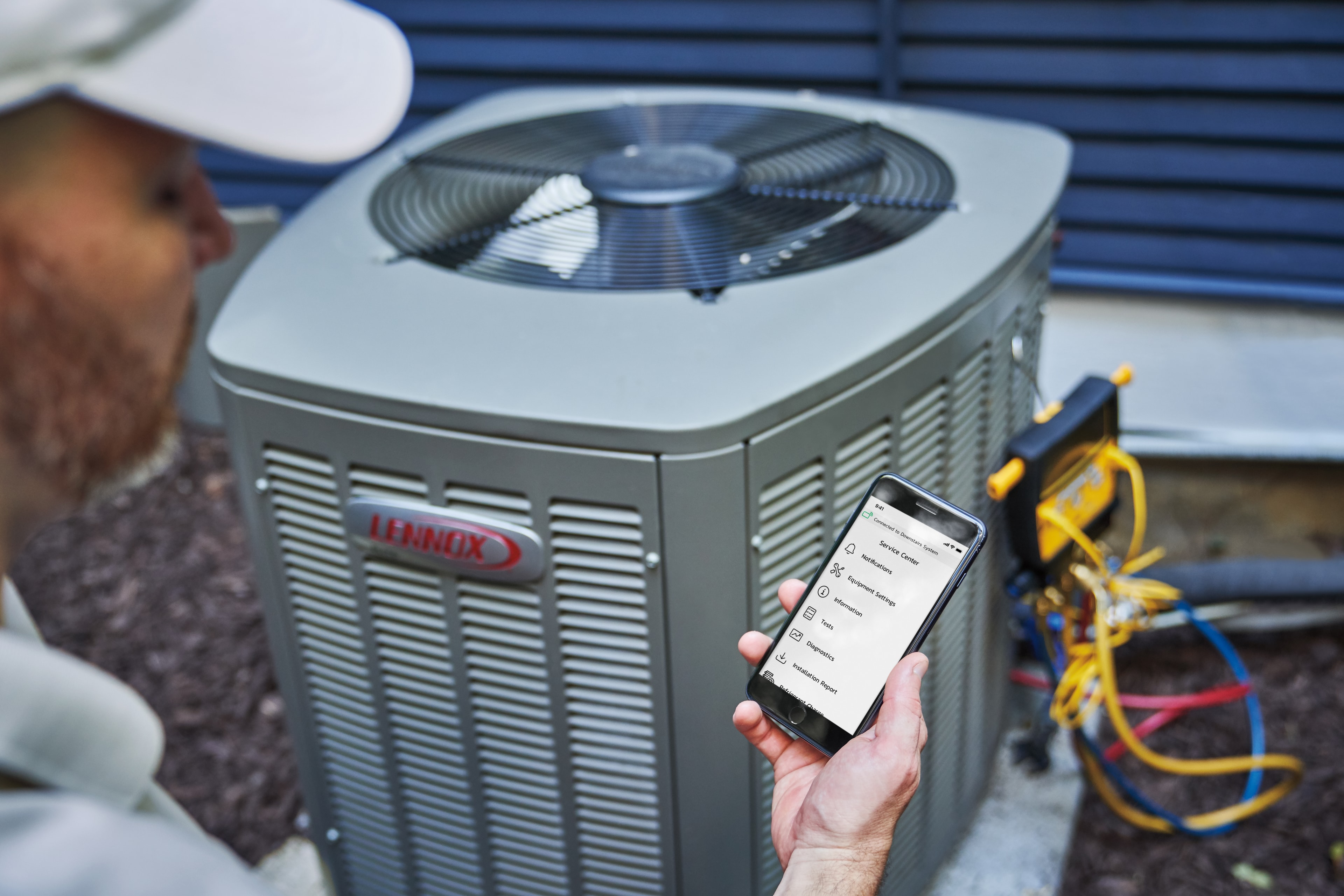 Lennox technician using dealer diagnostic app beside outdoor AC unit